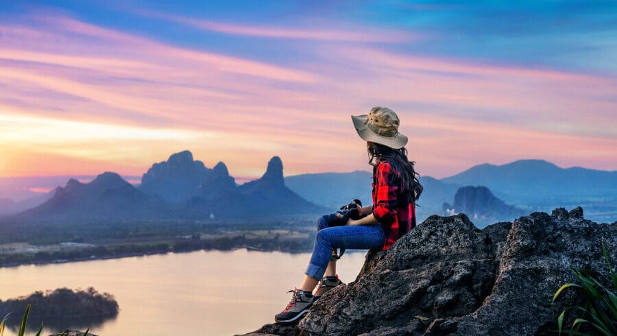 Woman sitting on rocks near water body
