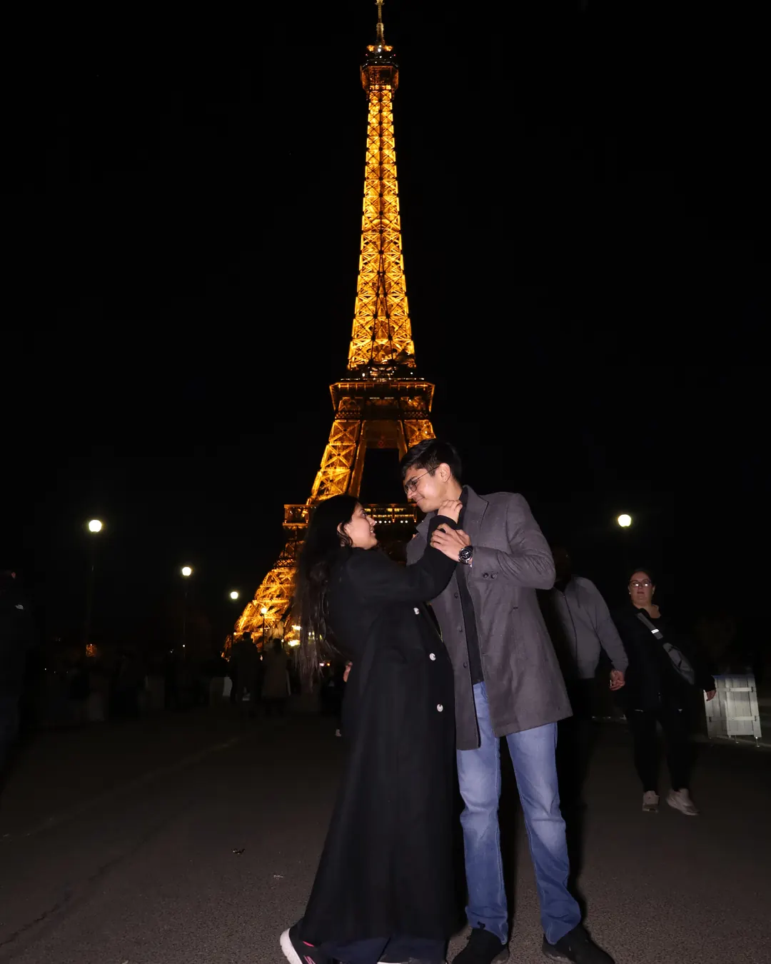 Customised Holiday or Group Tour? An Honest Comparison for Indian Couples and Families 4 Naviora Journeys clients, a couple, in front of the Eiffel Tower at night