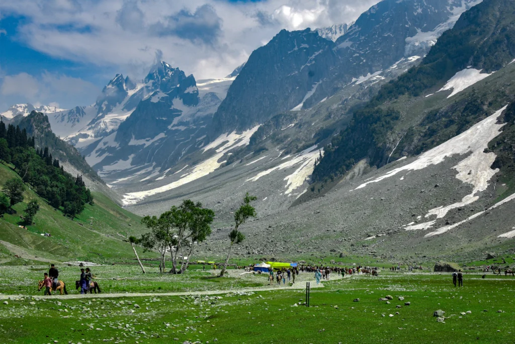 Kashmir Trip Cost from India (2026–27): What a 7-Day Trip Really Costs a Couple 5 Visitors on ponies in the Sonamarg meadow below snowy peaks