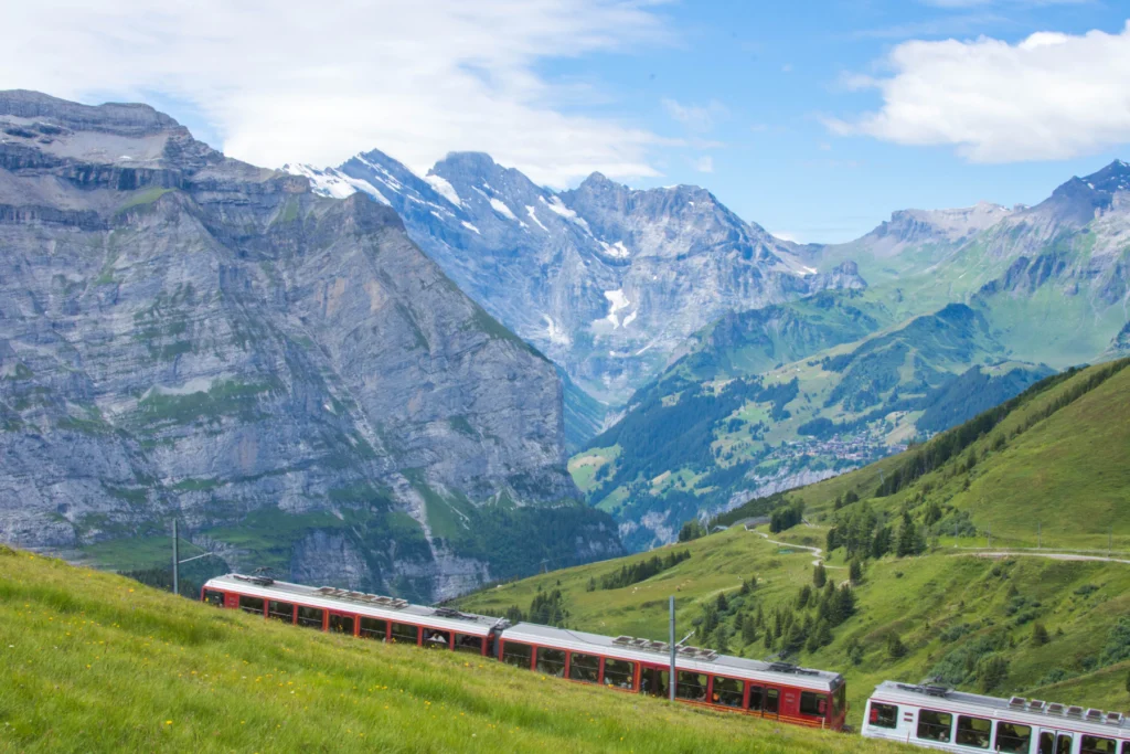 A Swiss train running through a green alpine valley